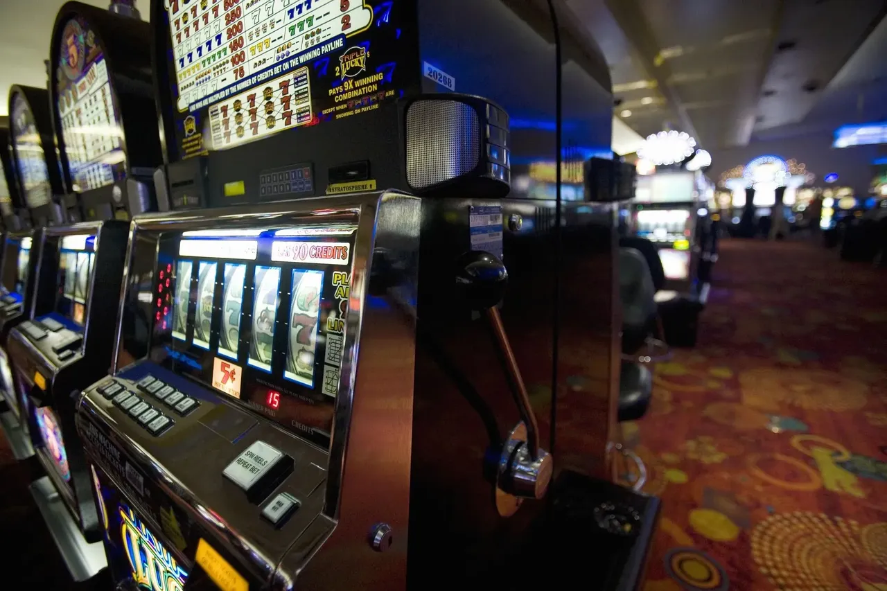 Řady výherních hracích automatů v kasinu Las Vegas s blikajícími světly