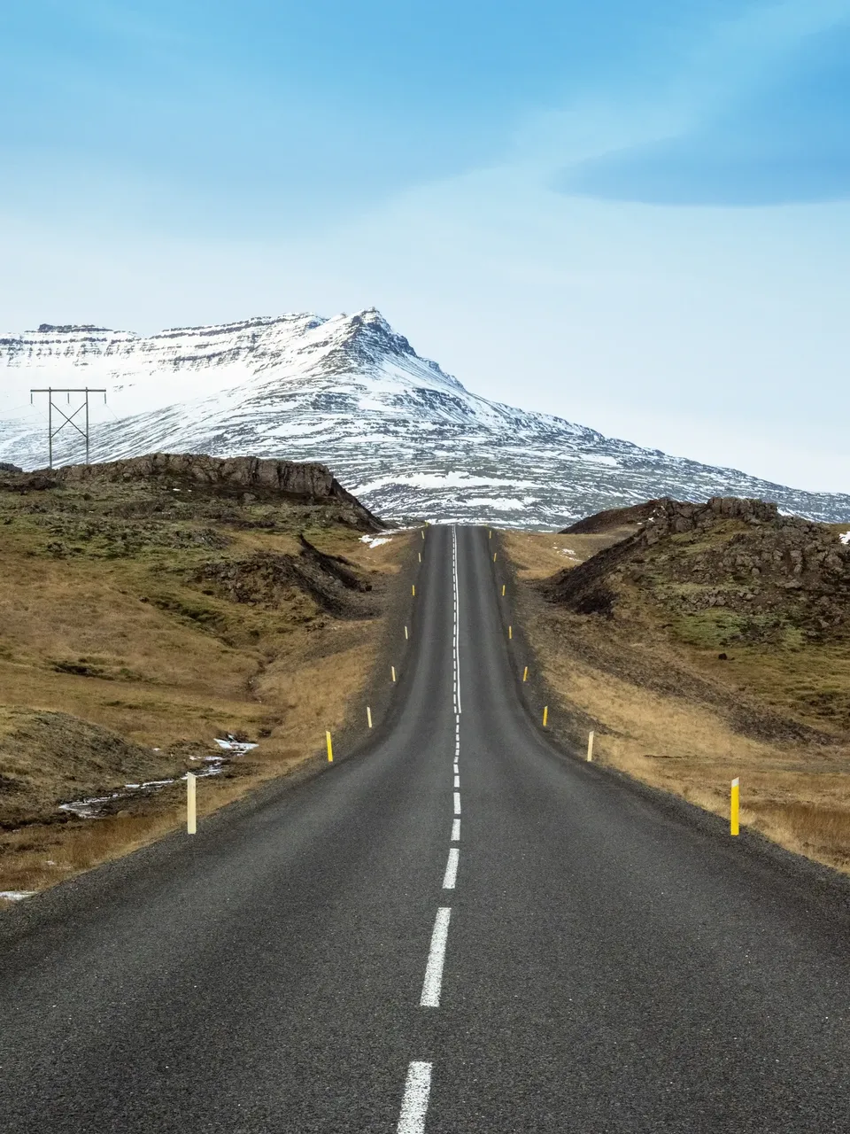 View of road ahead in Iceland with snowy mountain in background — Getty Images