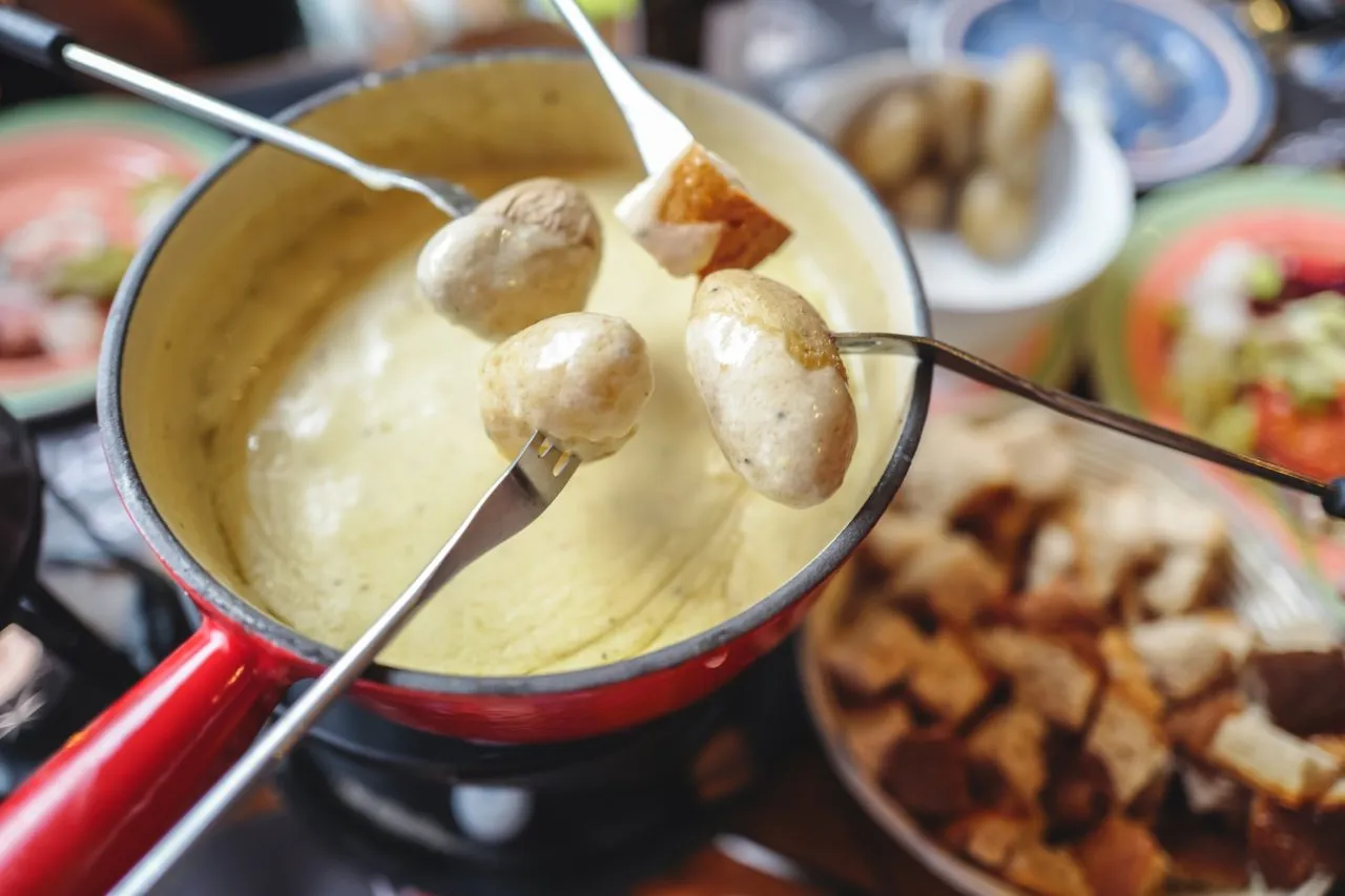 Classic Swiss cheese fondue with breads and potatoes, landmark of Switzerland