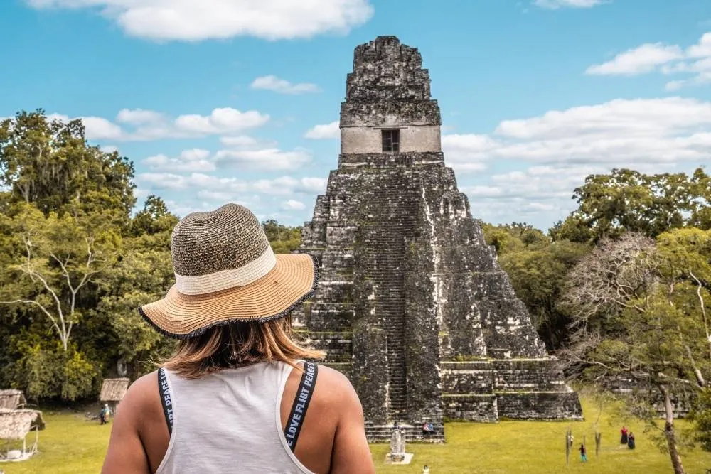 Tikal templom Guatemalában turistával az előtérben - Shutterstock
