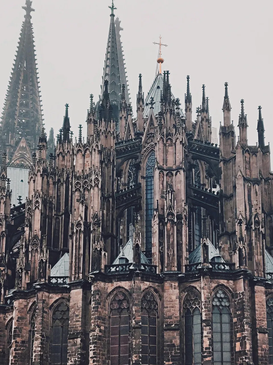 Close-up view of the Gothic spires and intricate architecture of Cologne Cathedral on a foggy day