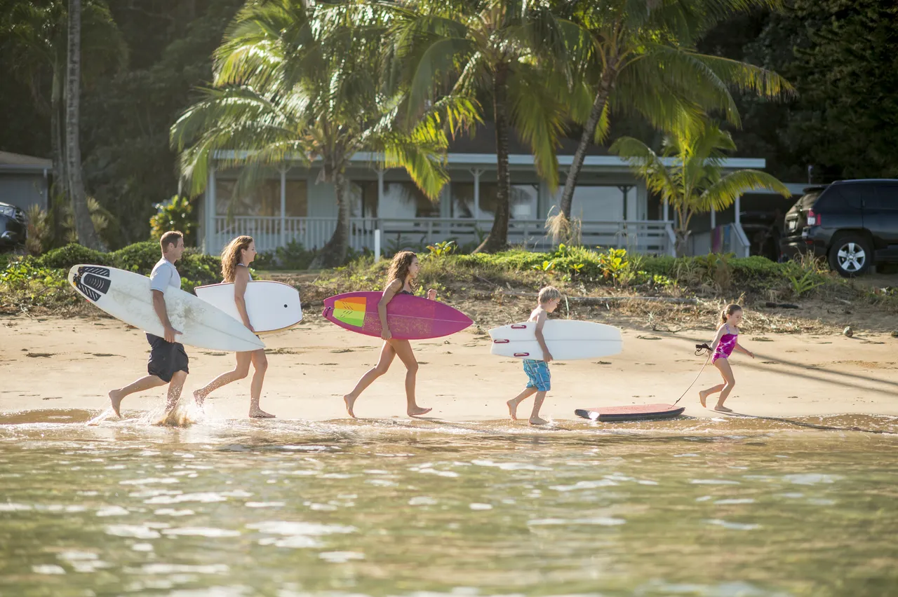 Parents with three kids on vacation going surfing in Hawaii, U.S.A.
