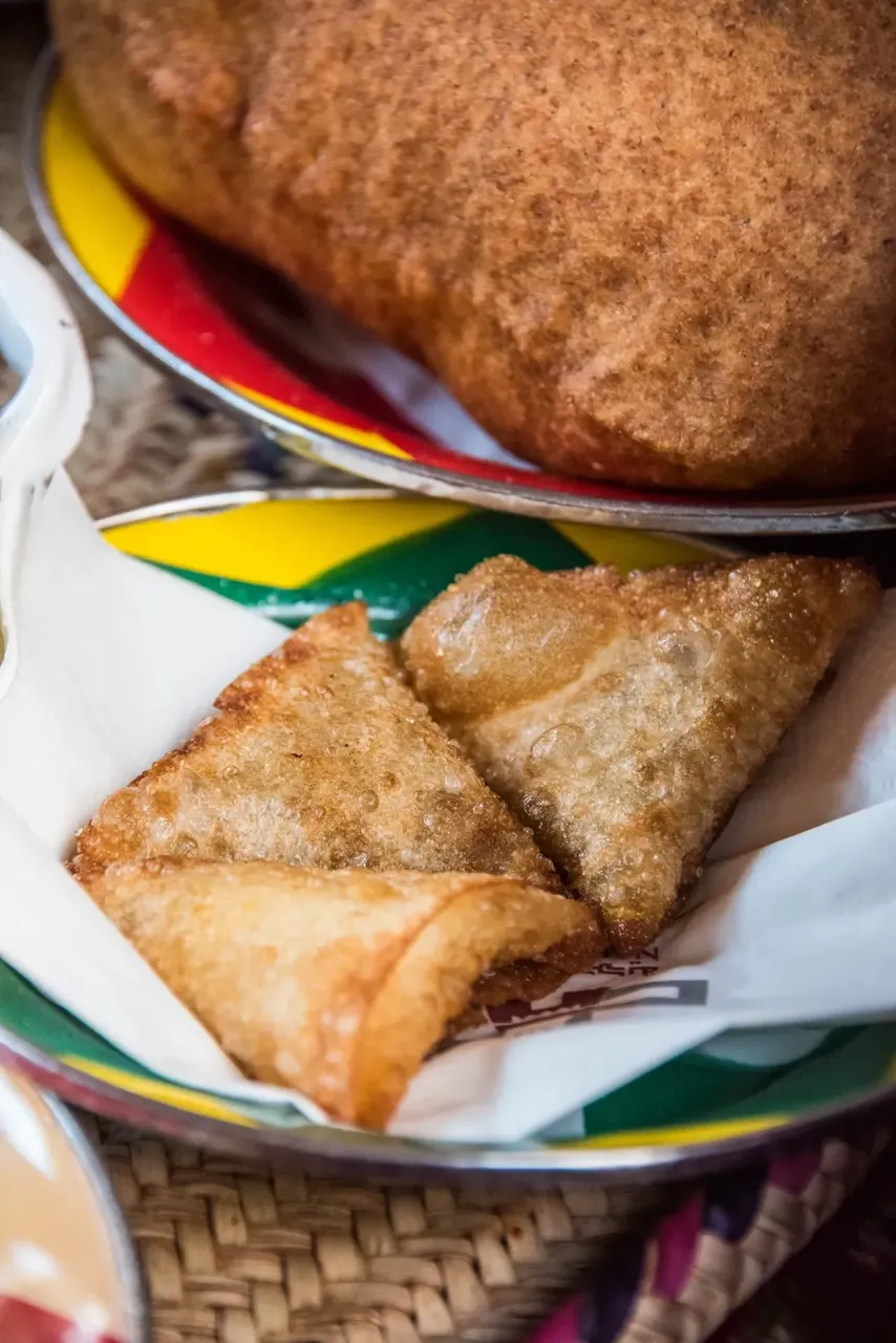 Crispy, golden triangular samboosas filled with savory ingredients, a popular snack in Jeddah