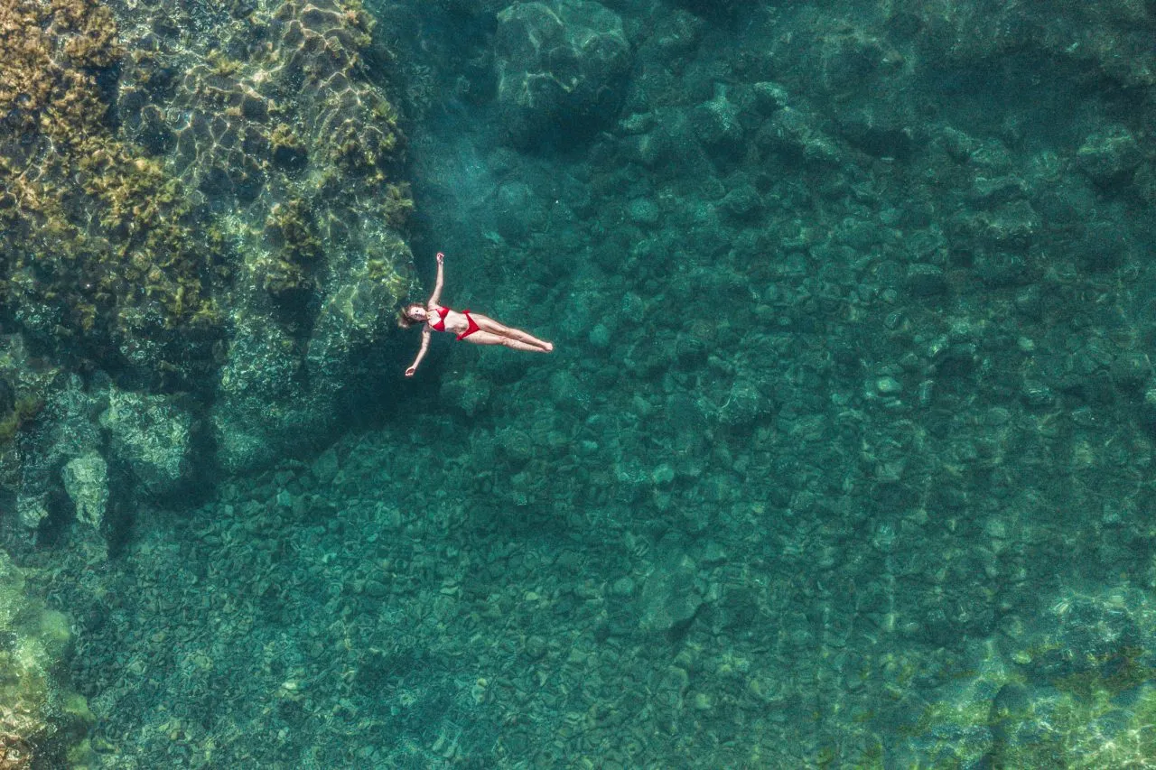 Young woman relaxing on a natural pool