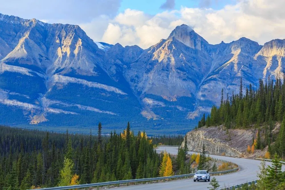 Canadian mountain scenery with car on road in the foreground — Shutterstock