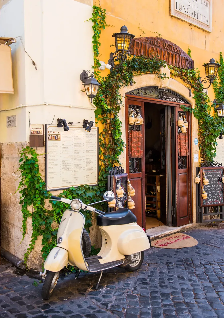 Vintage motorbike parked outside of a trattoria — Shutterstock