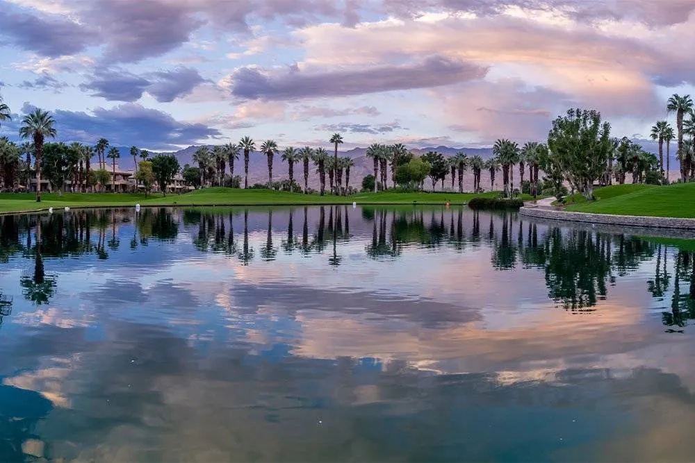 Panoráma kilátás a golfpályára egy tavon túl Palm Springsben hajnalban