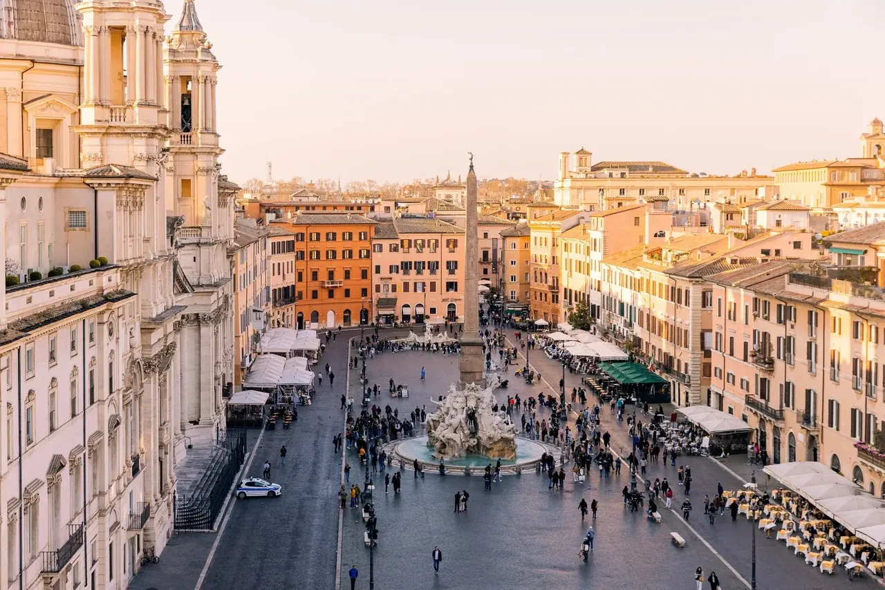 Tętniący życiem widok na Piazza Navona z pięknymi fontannami, tętniącymi życiem kawiarniami i tętniącymi życiem ulicami Rzymu.