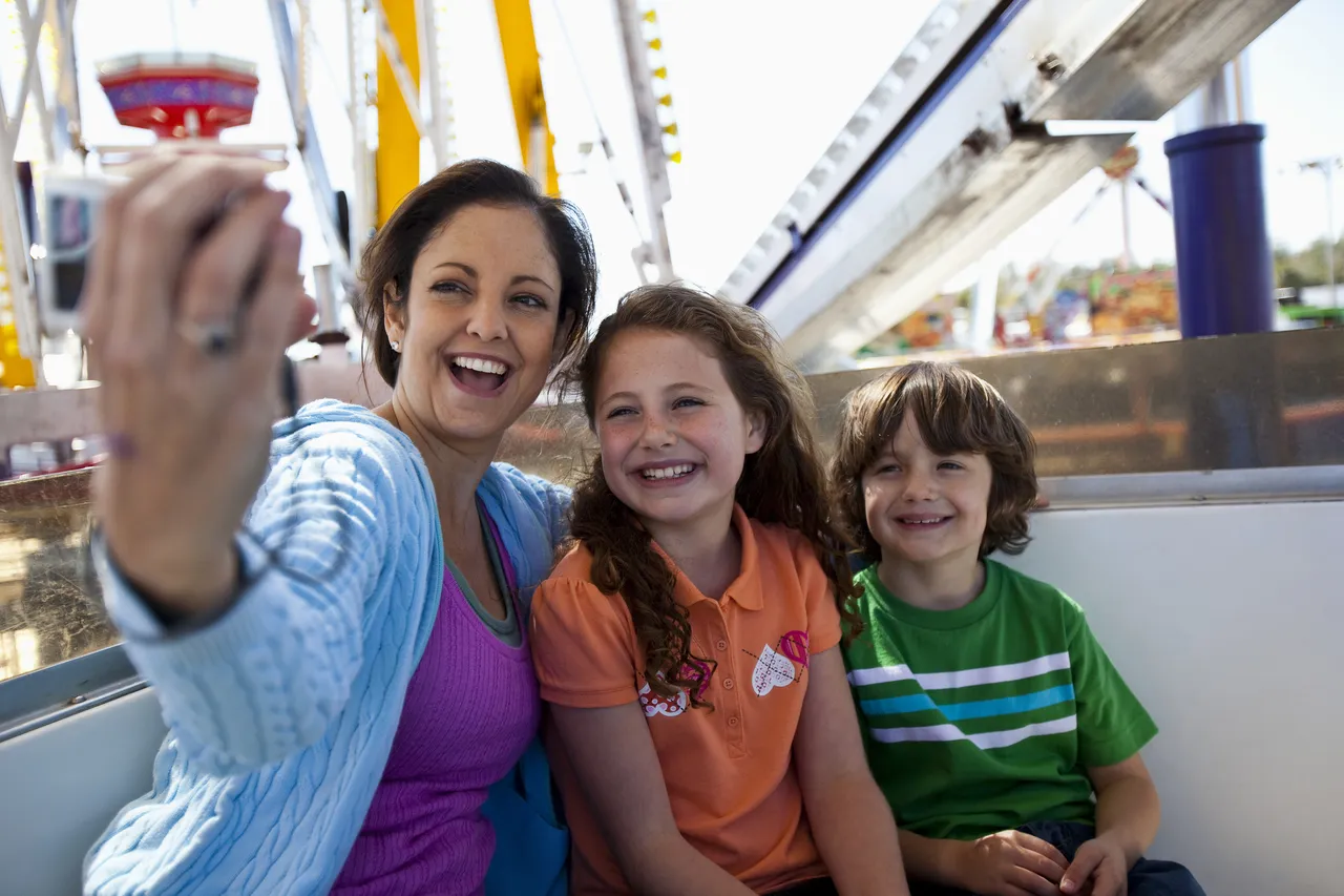 Mother and two kids taking selfie during the ferry wheel ride, U.S.A.