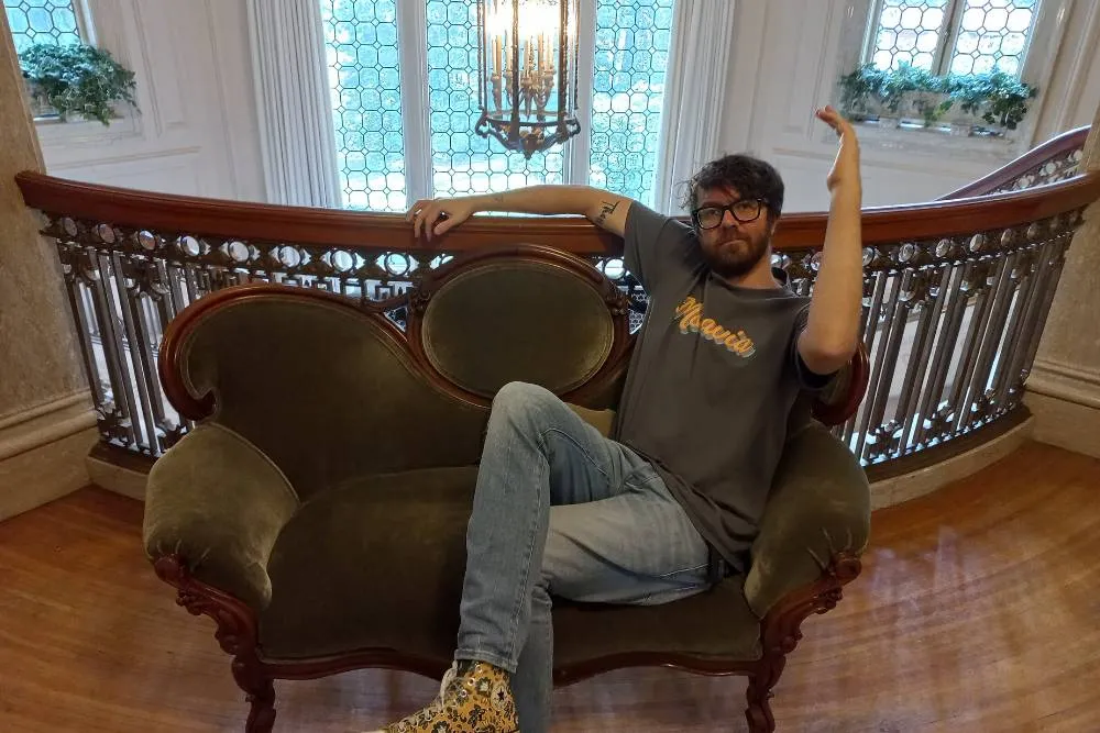 David lounging on luxurious sofa at Pittock Mansion — David Szmidt