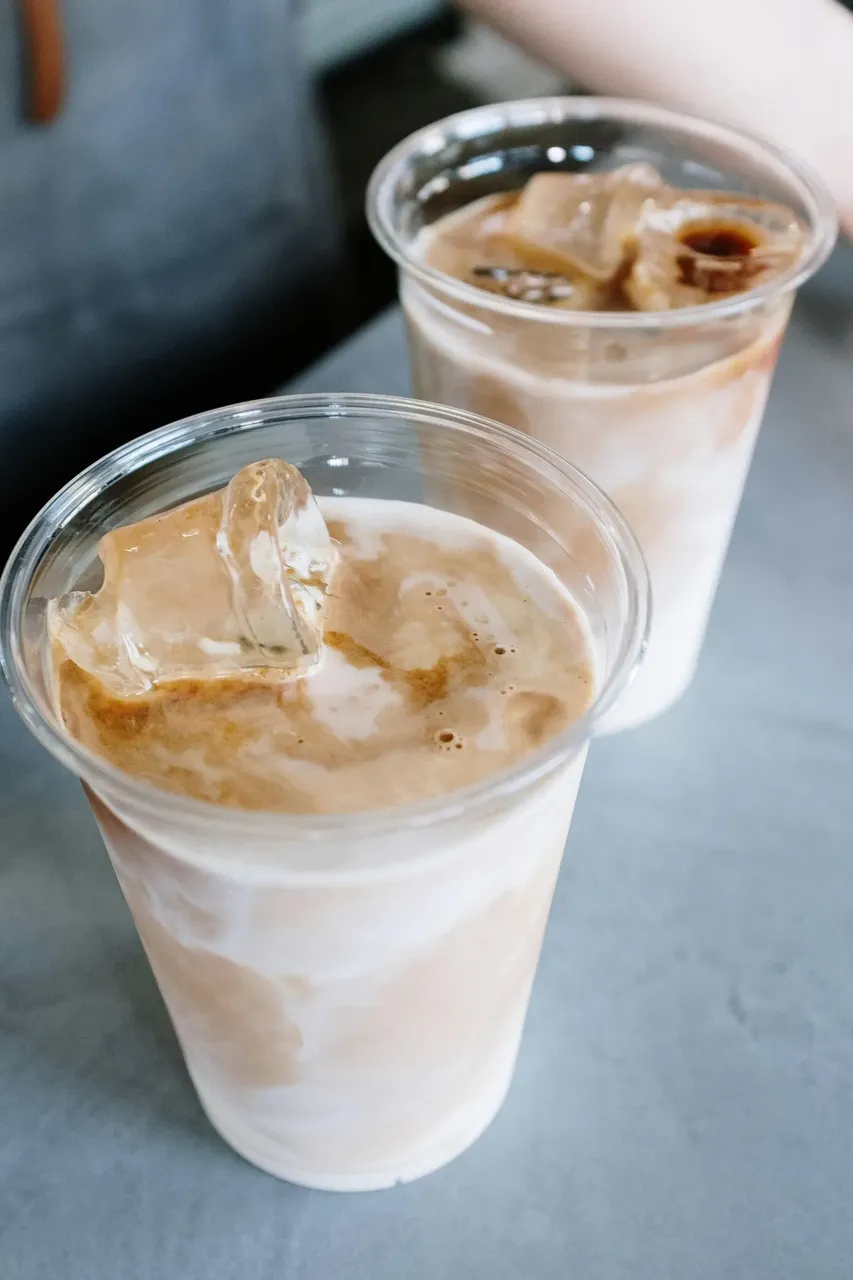 A chilled iced latte in a clear cup, with creamy layers of coffee and milk, served at Foxtail Coffee in Orlando.