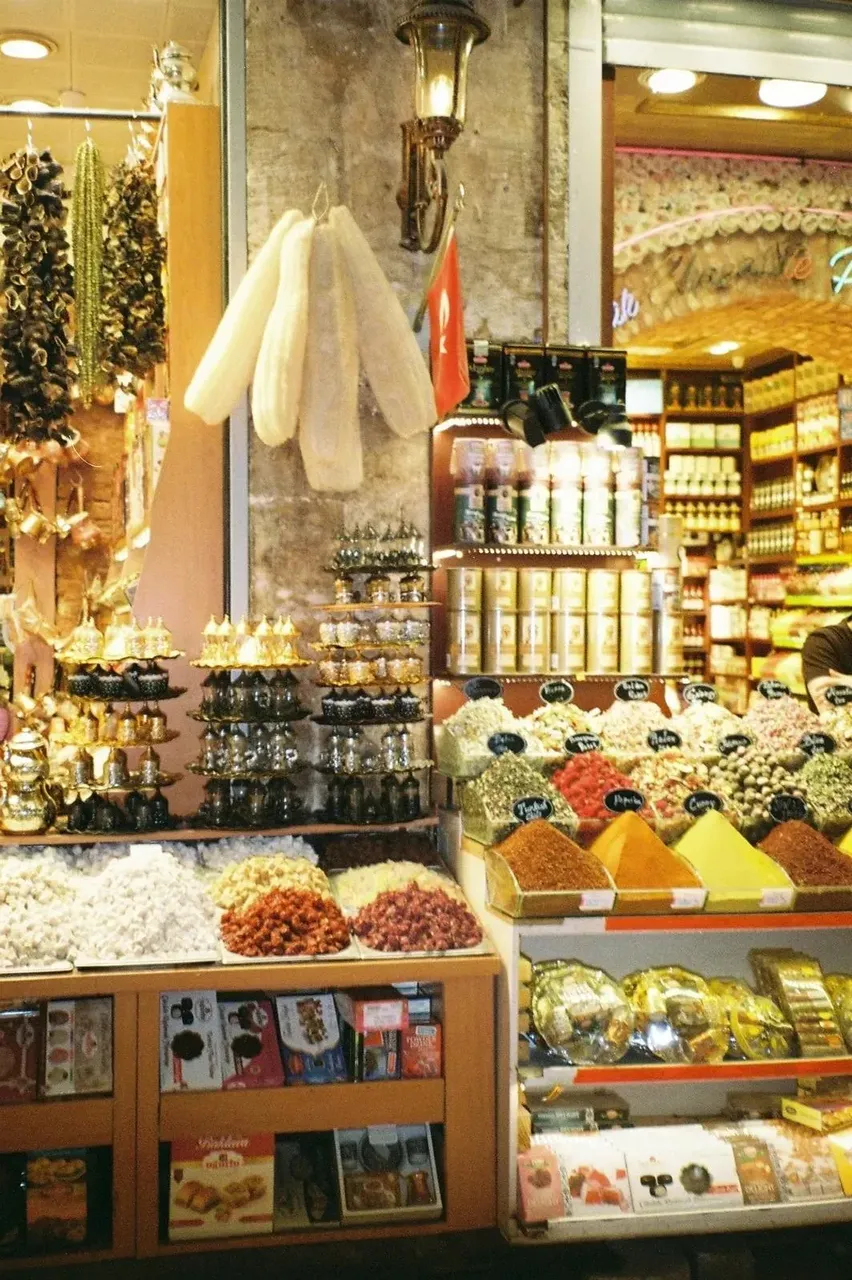 The vibrant Spice Market in Istanbul, displaying a myriad of colorful spices, dried fruits, and nuts in large open sacks, creating a rich tapestry of colors and aromas.