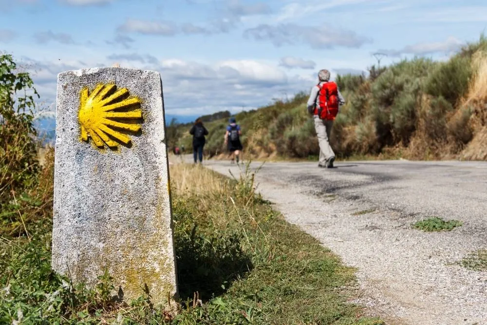 Iconic yellow shell symbol on a stone on the Camino de Santiago — Shutterstock