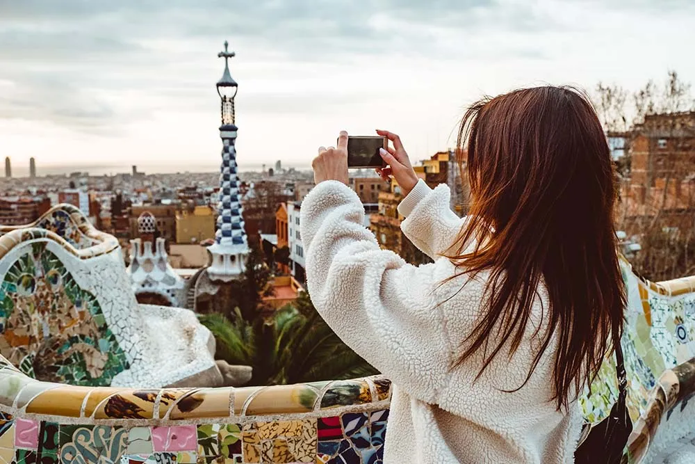 tourist woman in coat at Guell Park in Barcelona, Spain looking into the distance