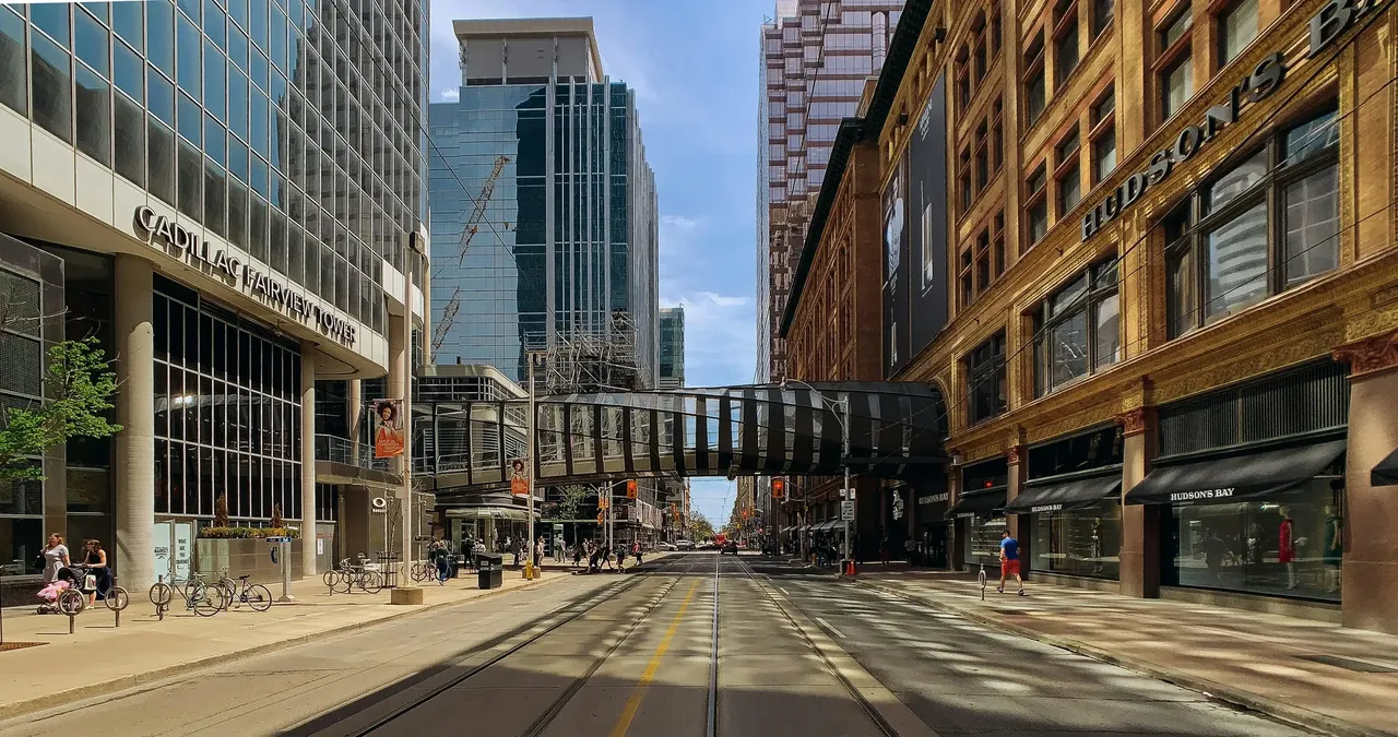 Bustling Queen Street West in daylight, lined with shops, cafes, and pedestrians