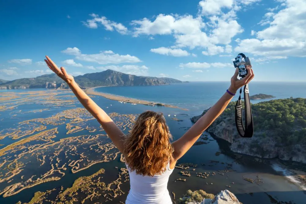 Rear shot of person with outstretched arms holding camera looking over İztuzu Beach — Getty Images