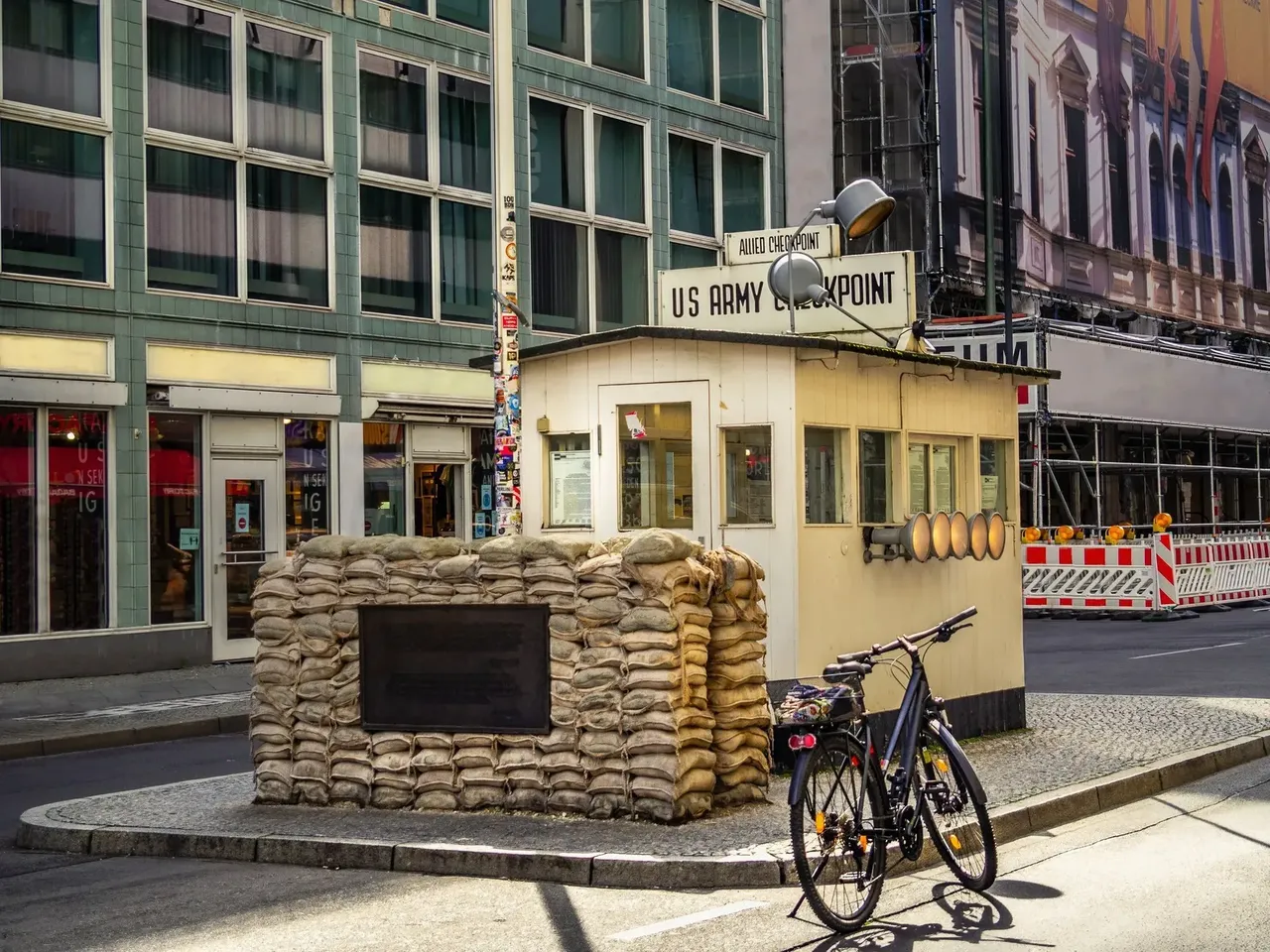 Checkpoint Charlie, the famous border crossing point between East and West Berlin, featuring historic signage and a replica guard booth