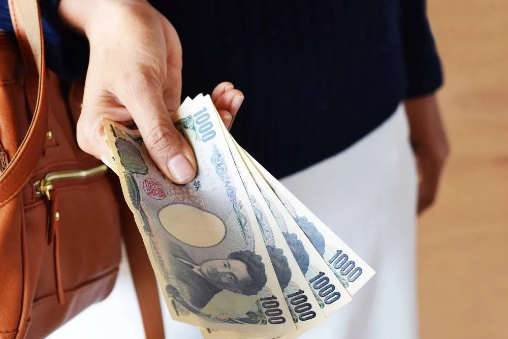 Person holding 4000 yen in cash — Shutterstock