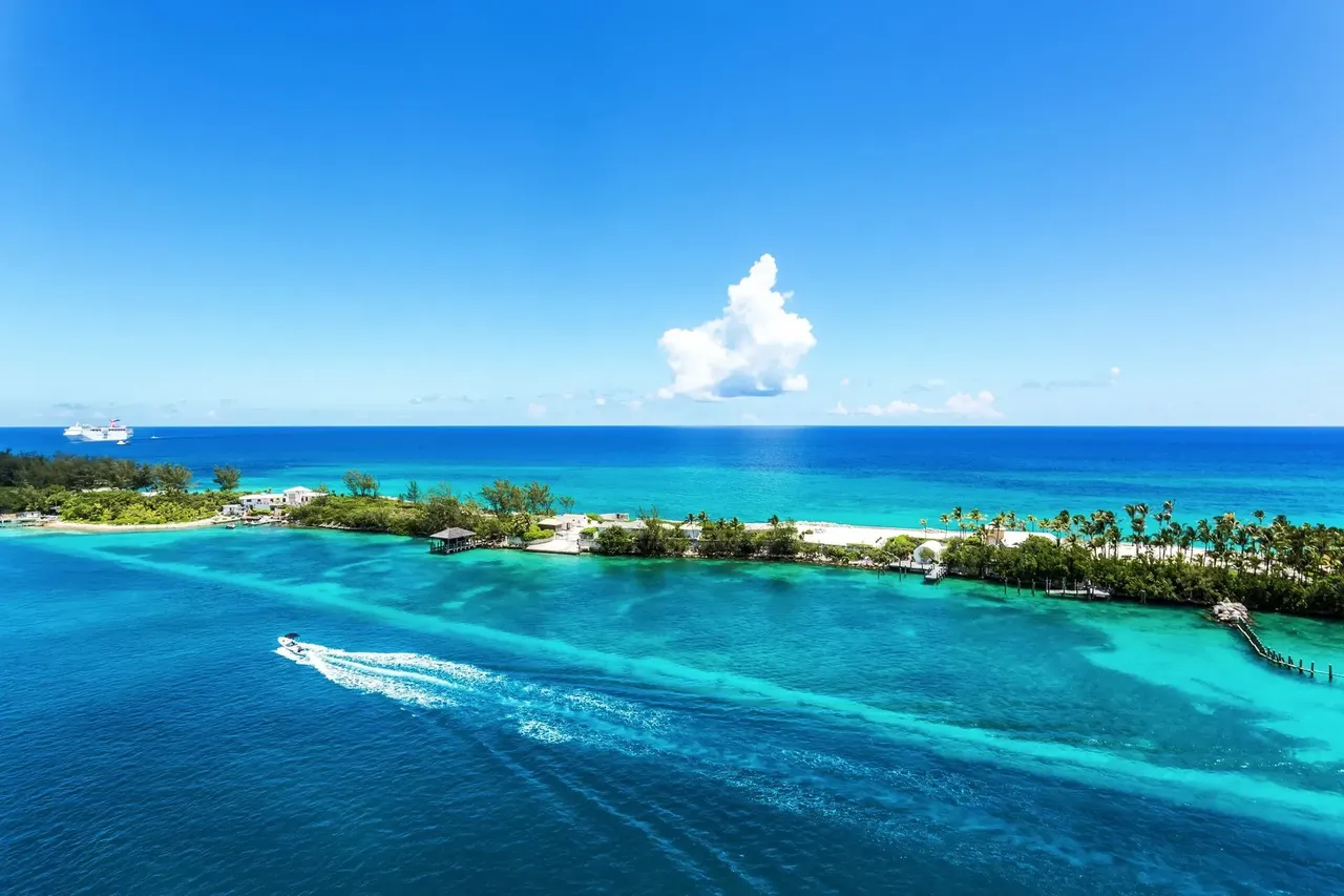 An aerial view of Nassau, Bahamas, showing a tropical island with clear blue water, white sandy beaches.