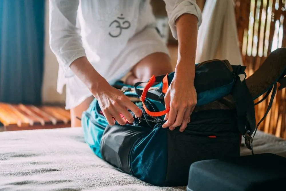 Person packing a holdall on a bed — iStock