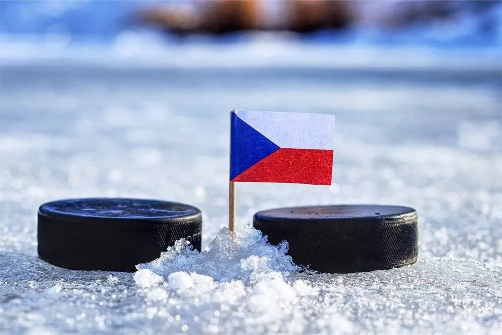 Two hockey pucks either side of a minature Czech flag