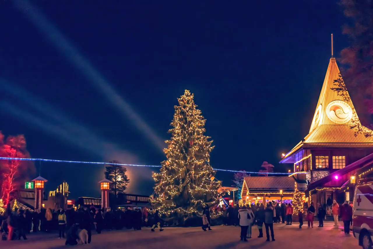 Rovaniemi w Finlandii. Rozświetlona choinka w wiosce Świętego Mikołaja nocą.