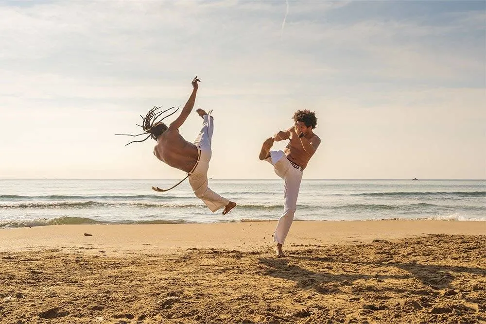 Capoeira practicers on the beach — Shutterstock