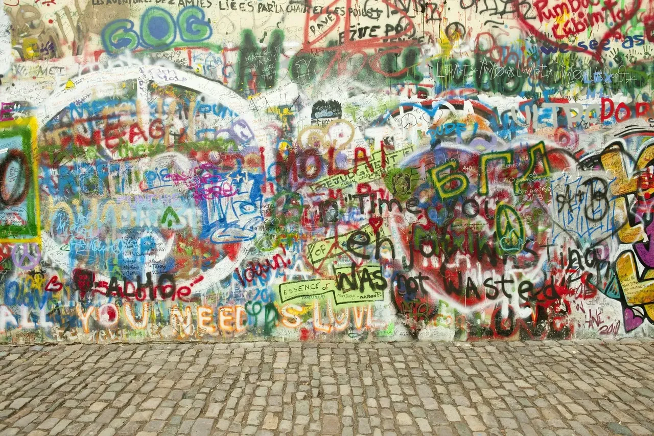 The Lennon Wall covered in colorful graffiti, drawings, and messages of peace