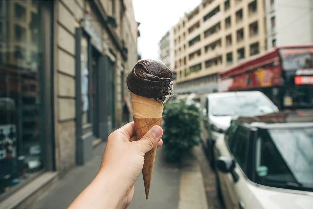 Ręka trzymająca lody na uliczce w Mediolanie.
