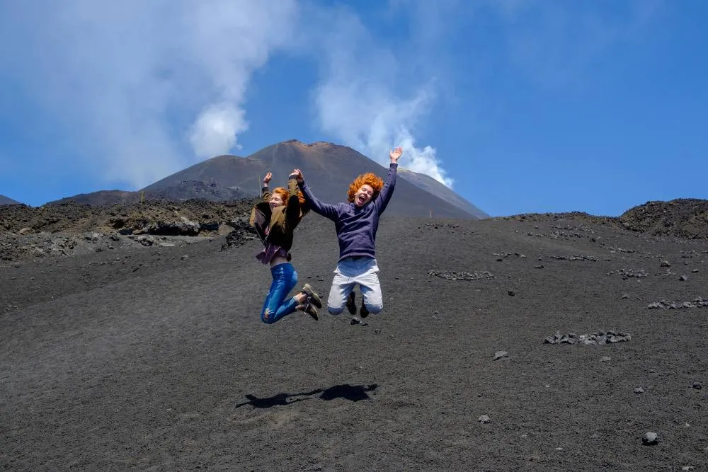 Young people jumping near Mount Etna — Getty Images