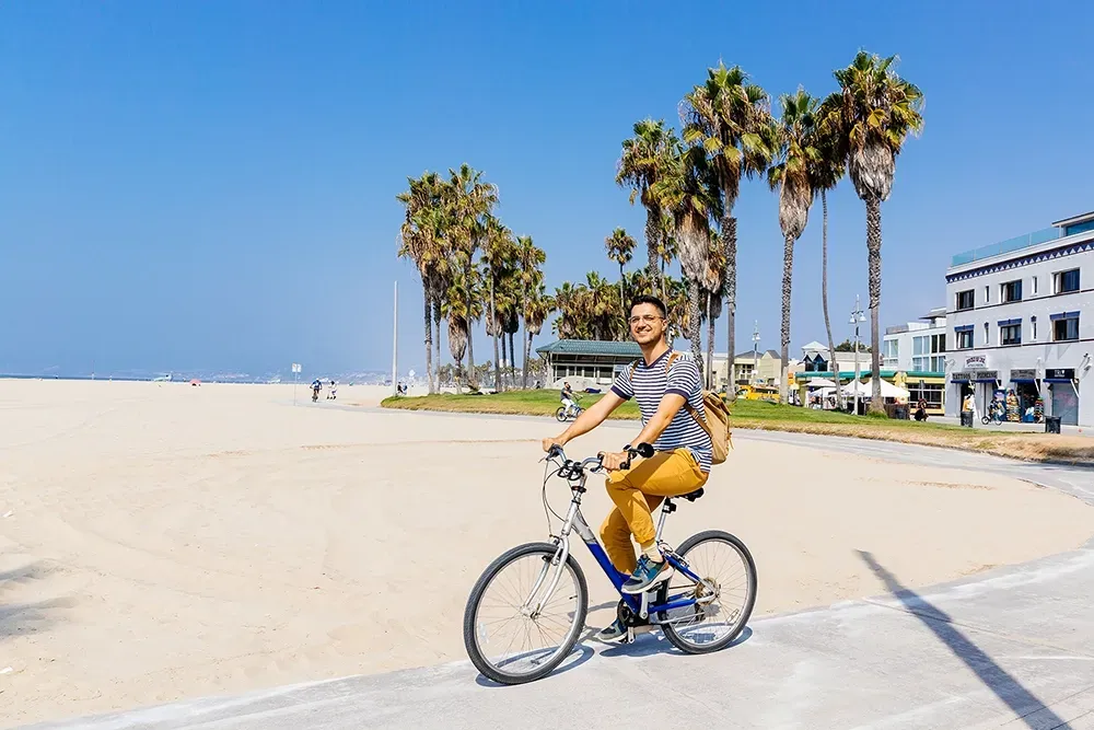 Osoba na rowerze na plaży w Los Angeles.