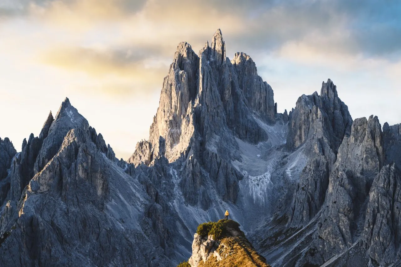 One person standing in front of sharp dolomites peaks, Italy