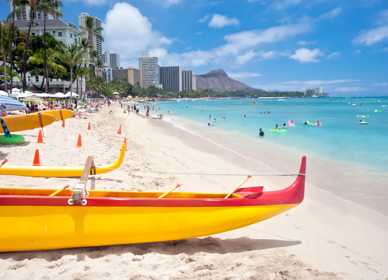 Pláž Waikiki s kánoemi a kráterem Diamond Head v pozadí. Waikiki, Honolulu, Oahu, Havaj, USA