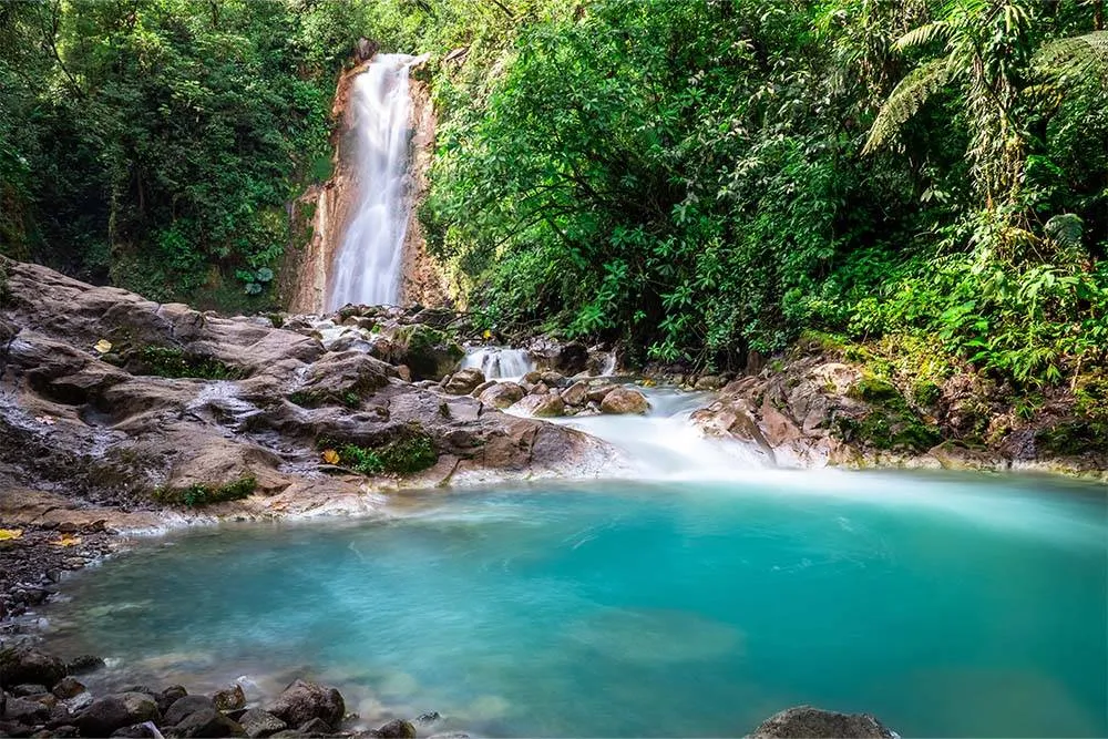 Waterfall and plunge pool in the sunlight in Costa Rica — Shutterstock