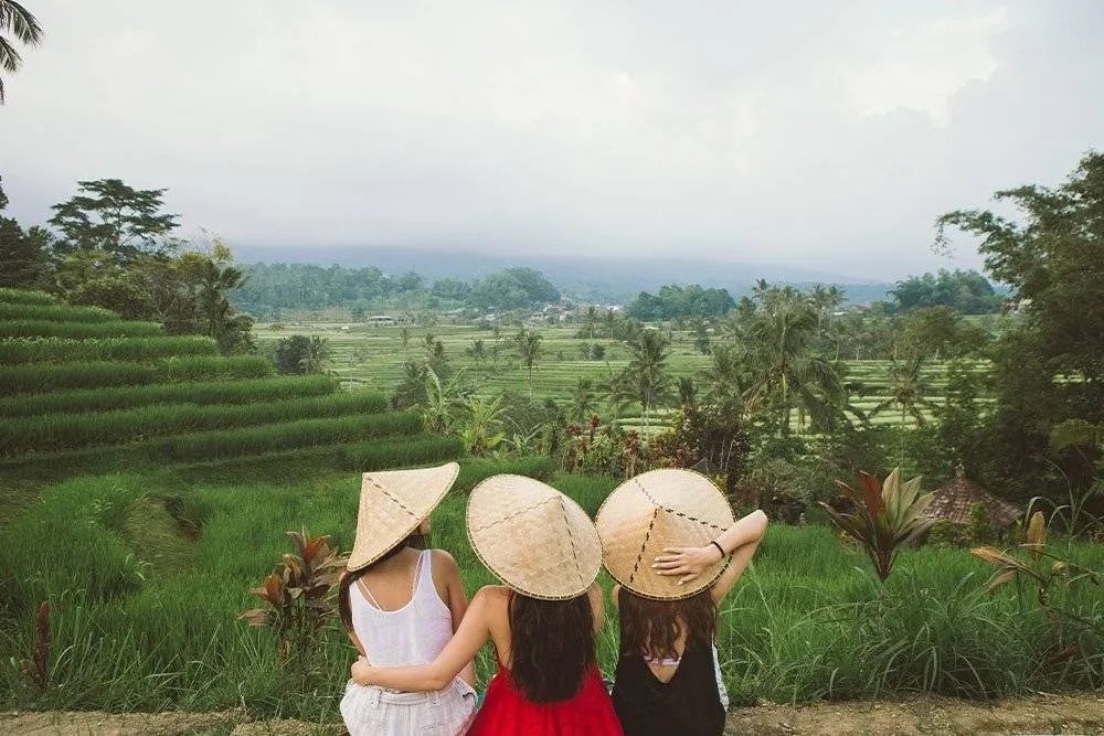 Three women sat looking at the view in rural Bali — Shutterstock