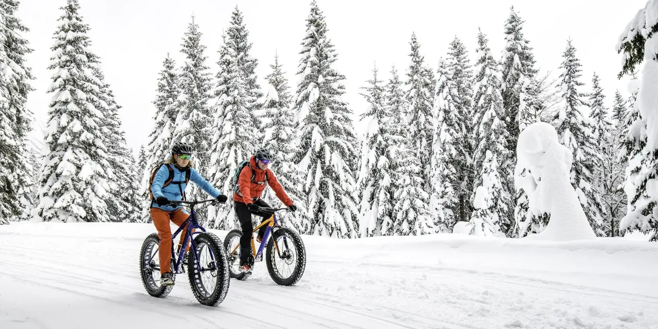 2 osoby na rowerach na śniegu