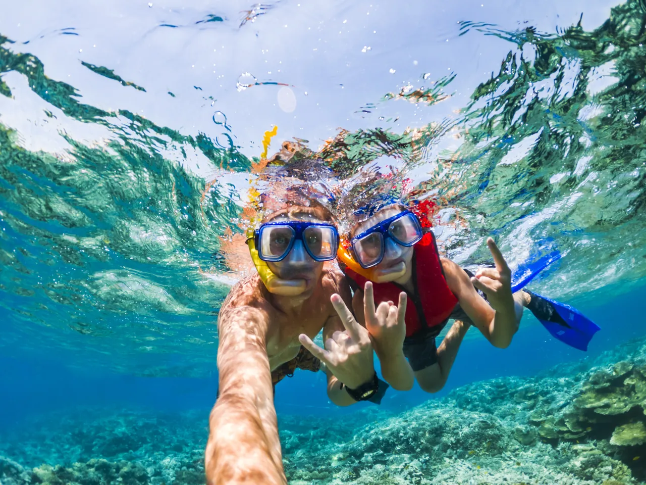 Father and son snorkeling near the coral reef. Vacation at sea