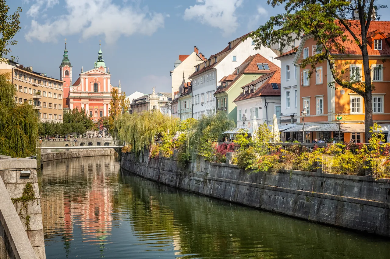 A folyócsatorna a szlovéniai Ljubljana óvárosában egy gyönyörű napon, a vízen megcsillanó napfénnyel