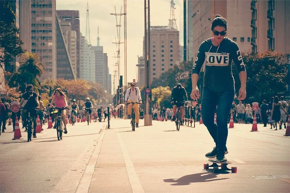 Skateboarder in the foreground of a busy street in São Paulo