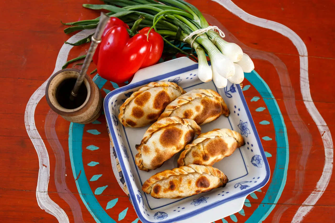 Freshly baked Argentine empanadas filled with savory meat, served on a rustic plate in Buenos Aires