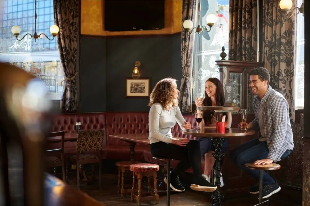 Friends drinking in a traditional English pub — iStock