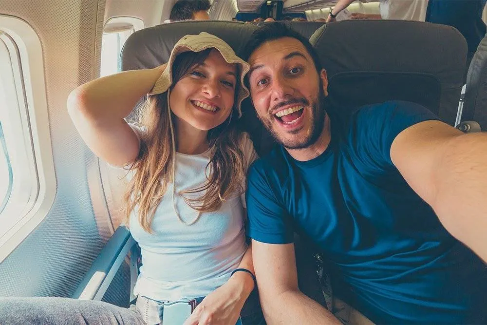 Selfie of an excited couple on an airplane — Shutterstock