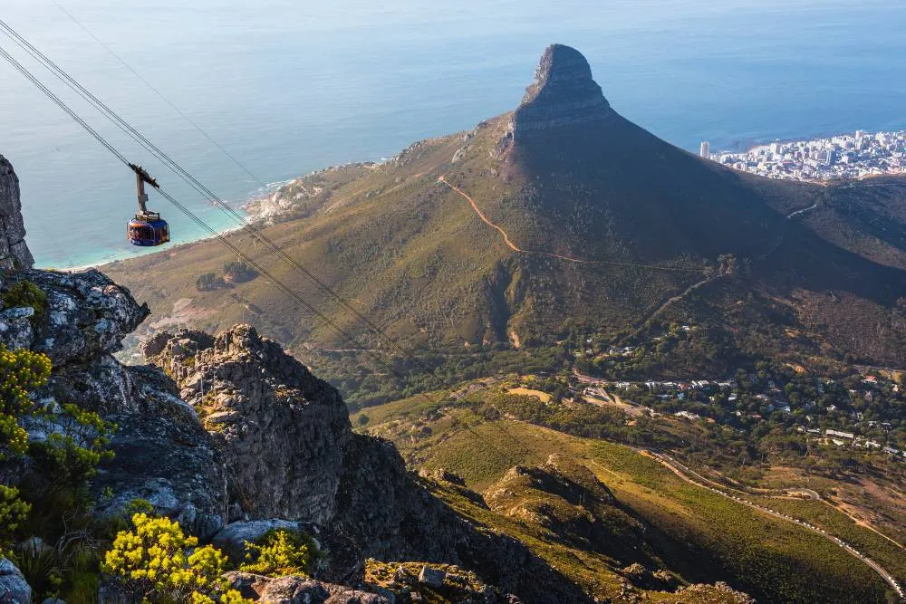 Cable car ascending in Table Mountain National park with Lion’s Head mountainin background — Getty Images