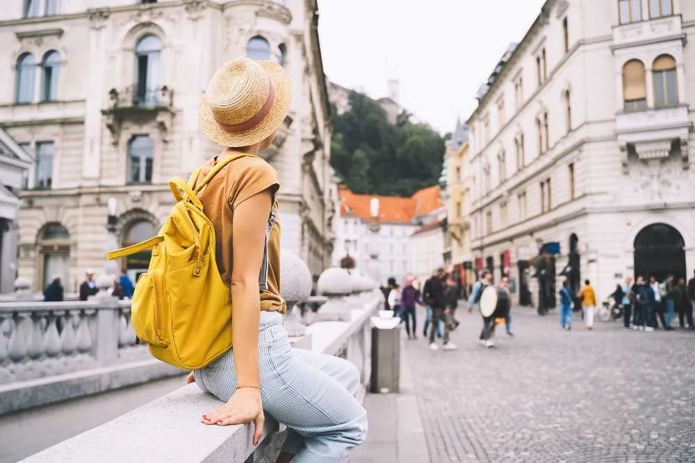 Young girl with backpack on Triple Bridge in heart of Ljubljana Old Town, Slovenia — Shutterstock