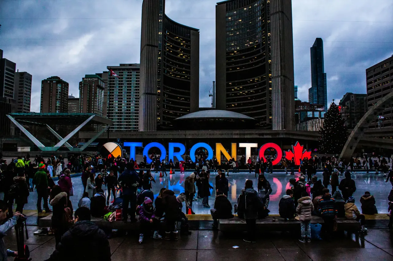 Illuminated Toronto sign at night, glowing brightly in vibrant colors