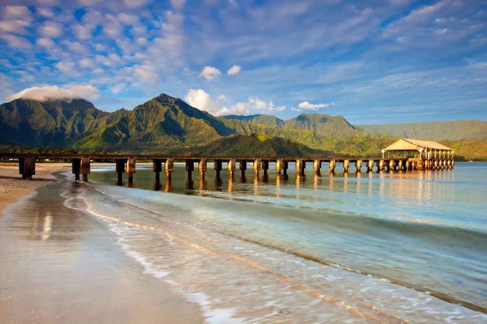 Hanalei Beach with pier and mountains in background — Getty Images