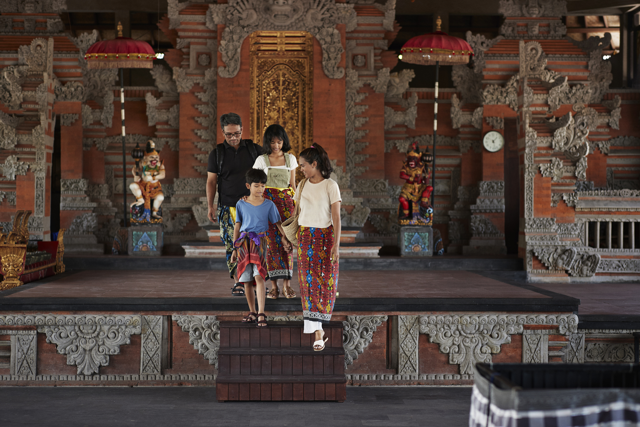Family with a son and daughter moving down temple stairs in Ubud, Indonesia