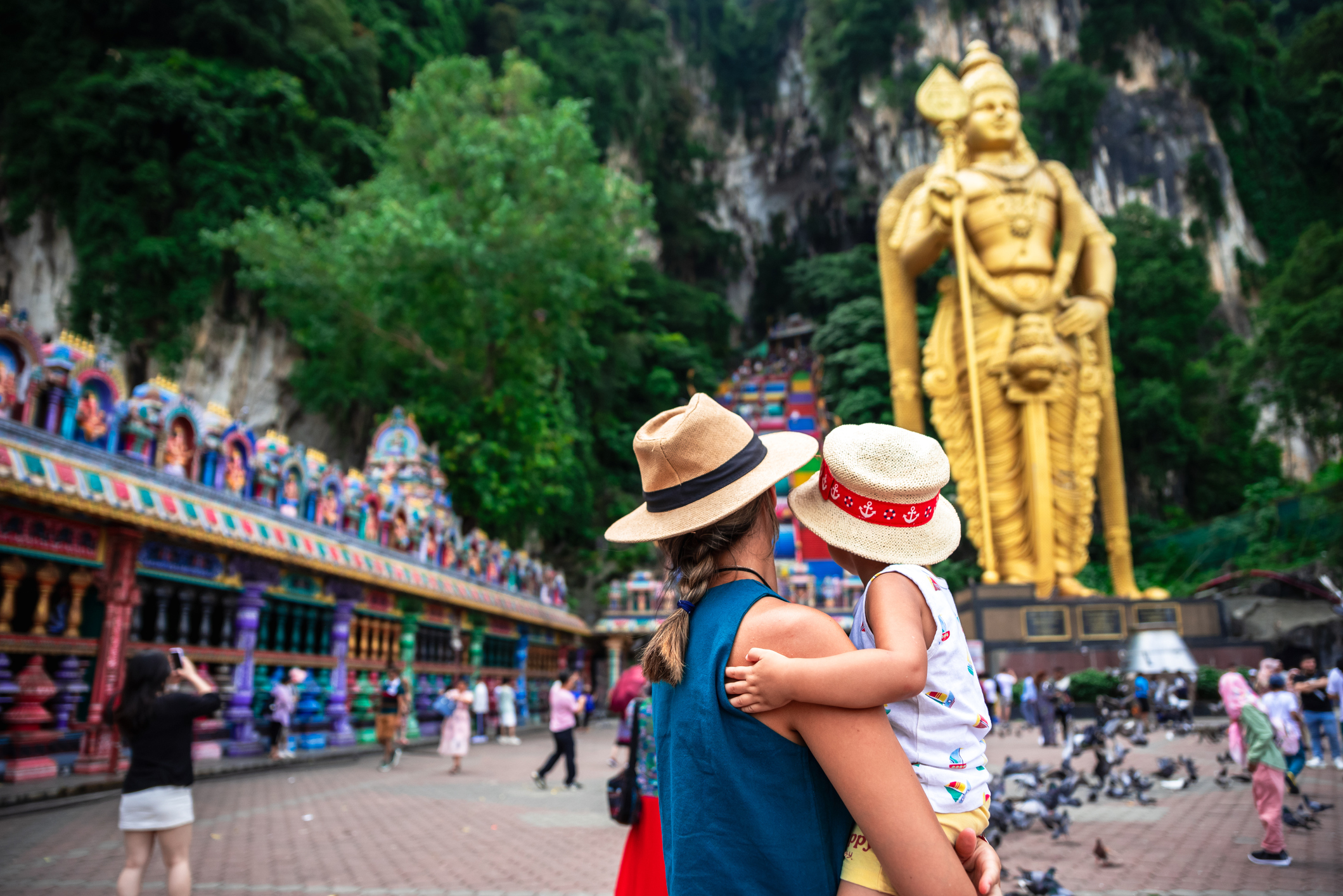 Mother holding her child in hands while looking at Batu Caves, Kuala Lumpur, Indonesia